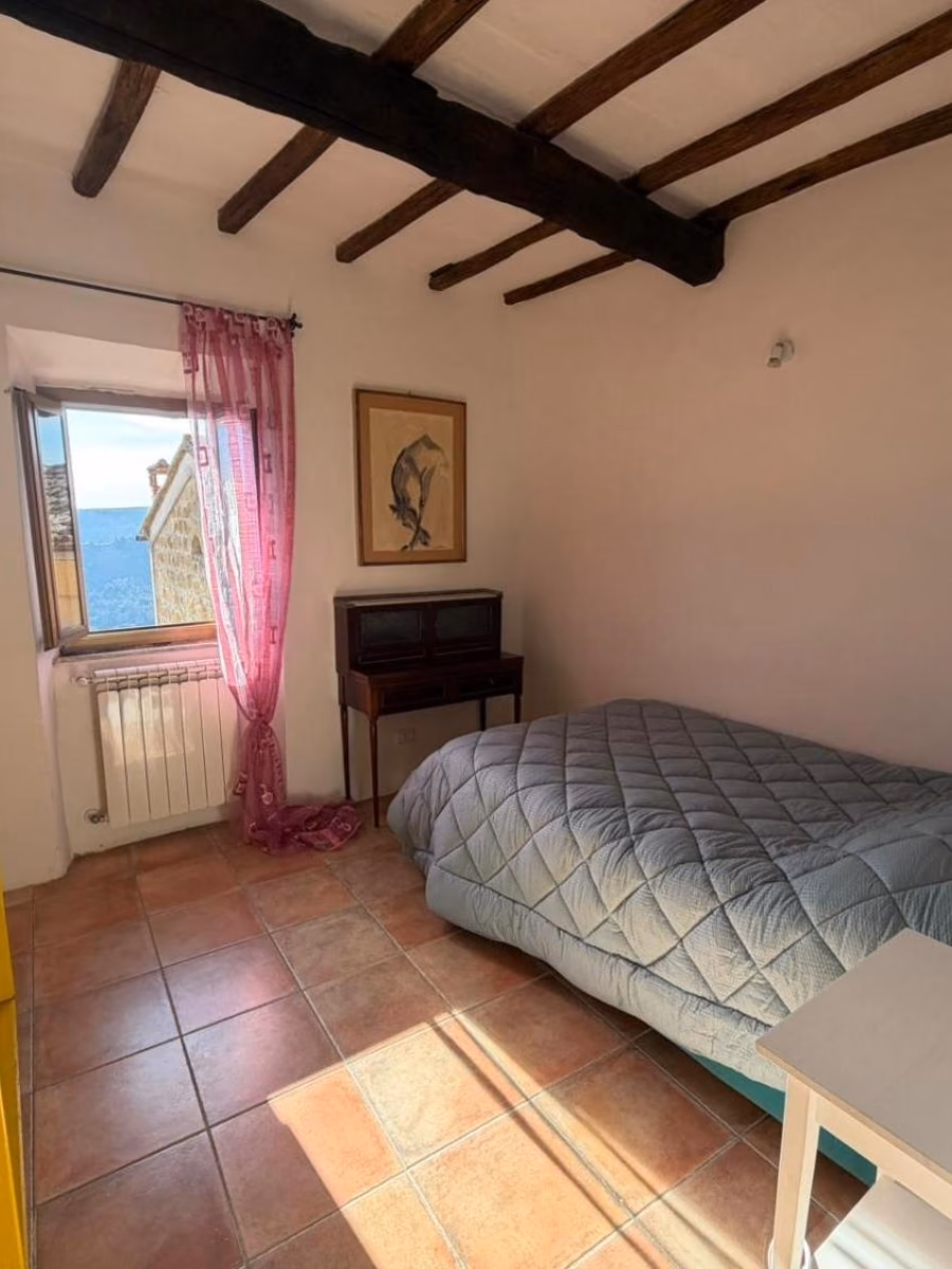 Una camera da letto matrimoniale di Luce su Civita, con la finestra affacciata sul borgo
